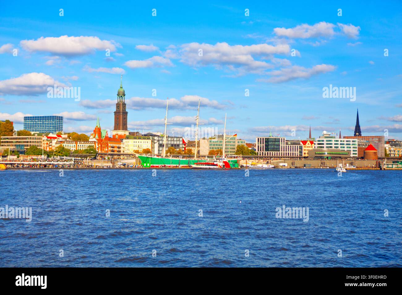 Vista sul lungomare di Amburgo che mette in risalto il centro storico della città e lo scafo verde distintivo della nave museo Rickmer Rickmers. Cupola maestosa in rame di St. Foto Stock