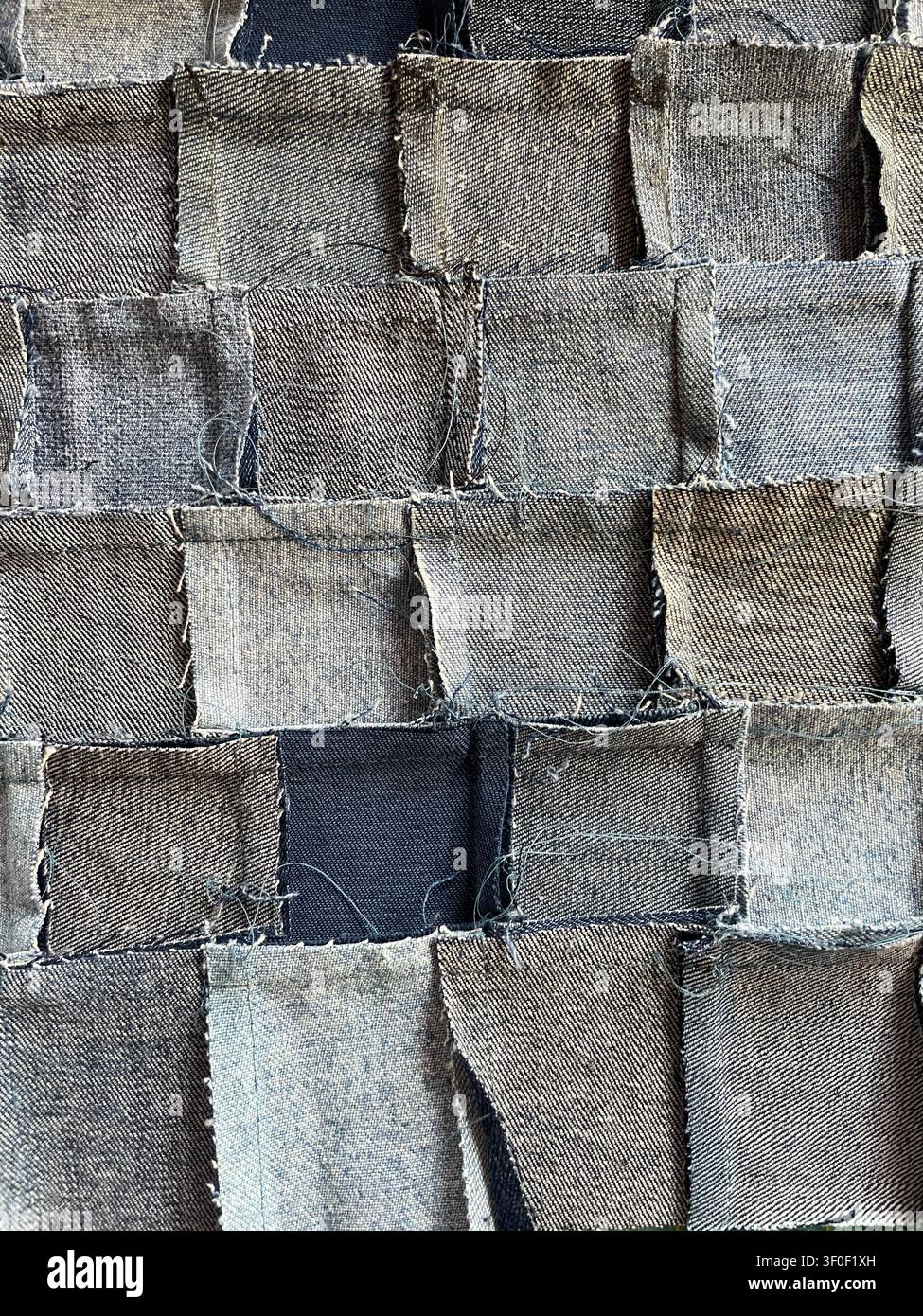 Prima di un tessuto patchwork in denim fatto a mano, tessuto con pezzi di jeans riciclati, perfetto per temi tessili e di upcycling Foto Stock