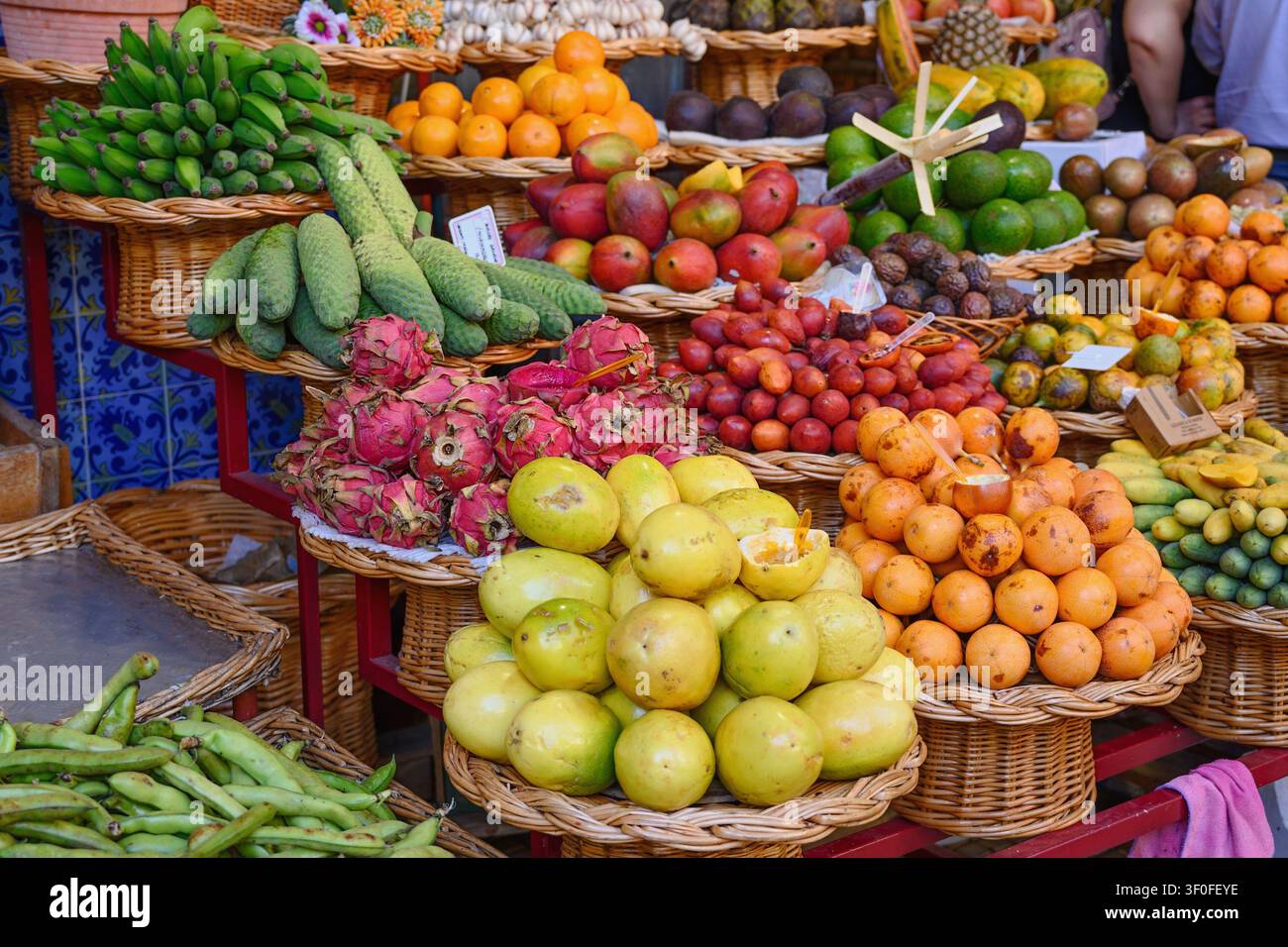 Stallo di frutta colorato al famoso mercato degli agricoltori di Funchal, Madeira, che espone una grande varietà di frutti tropicali ed esotici, tra cui la frutta del drago. Foto Stock