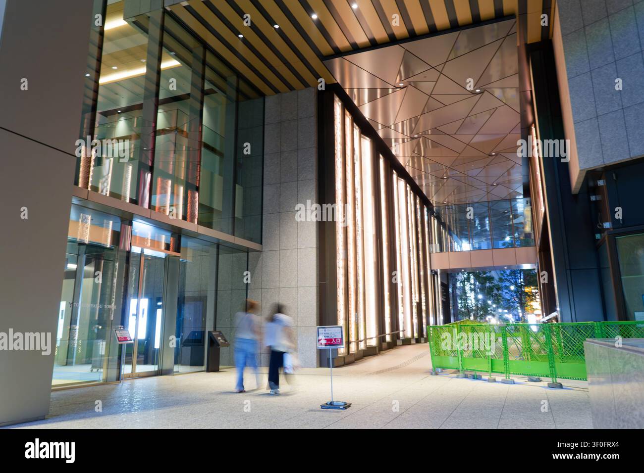 Elegante ingresso in vetro a un grattacielo di uffici premium nel distretto di riqualificazione di Yaesu a Tokyo, rappresentativo dell'architettura aziendale contemporanea Foto Stock
