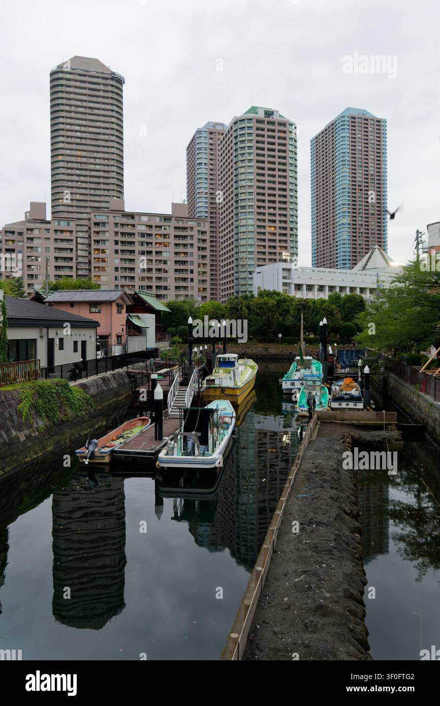 Canale storico a Tsukuda, Tokyo, dove un corso d'acqua del periodo Edo, un quartiere tradizionale dell'era Showa e grattacieli residenziali moderni coesistono, illustrazione Foto Stock