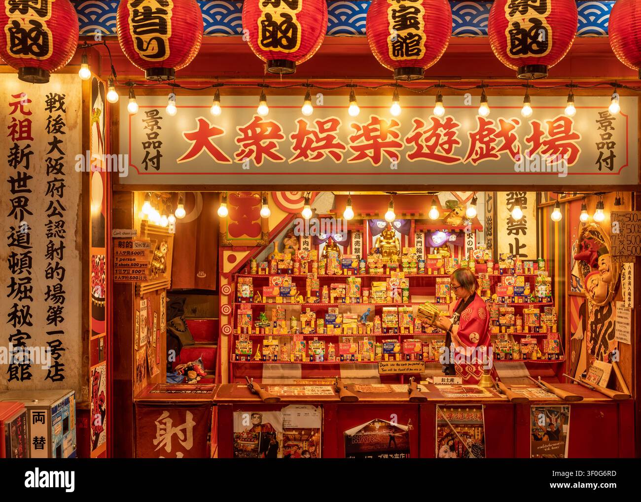 Vetrina caldamente illuminata di un salone giochi tradizionale o luogo di divertimento di notte, Osaka, Giappone Foto Stock