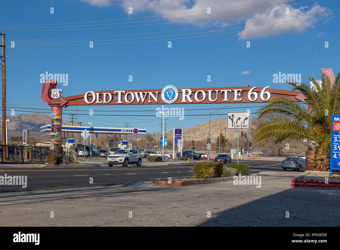Victorville, California, USA - 23 gennaio 2026: l’arco al neon della Route 66 del centro storico di Victorville che si estende sul traffico. Foto Stock