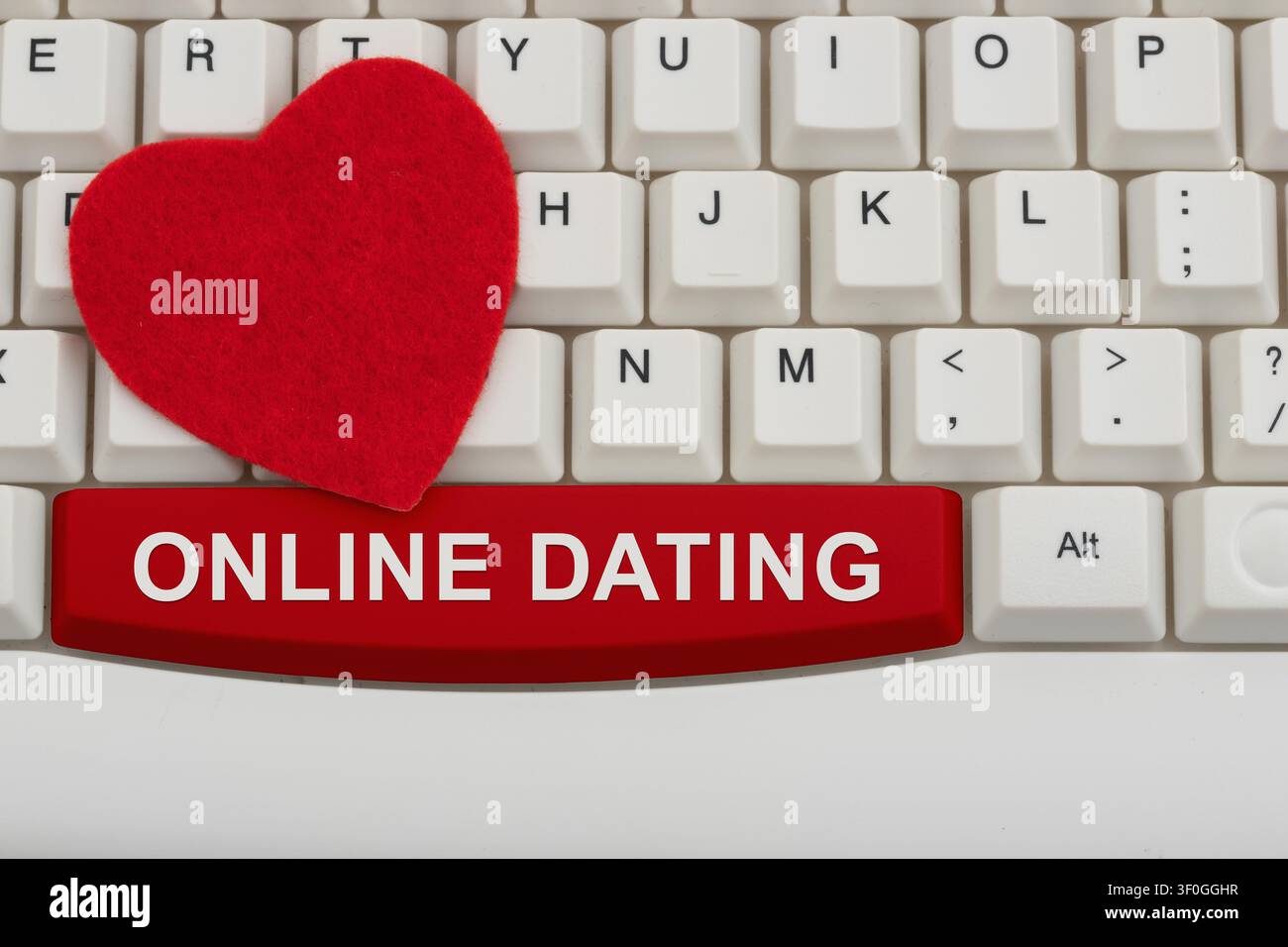 Testo di appuntamenti online con un cuore rosso su una tastiera bianca del computer per incontrare persone con le app Foto Stock