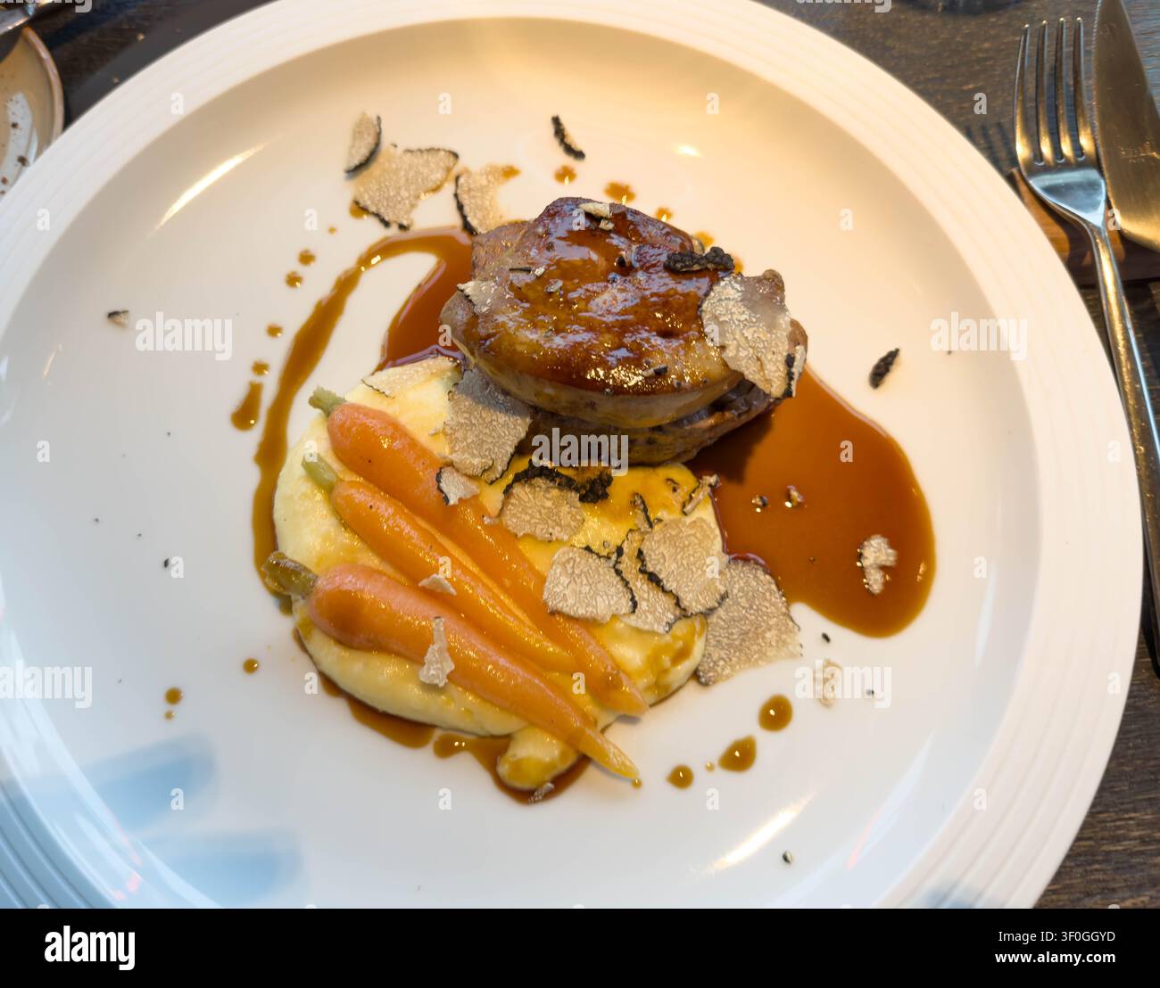 Foto di filetto di manzo con purè di patate al foie gras e tartufo e carote, servito in un ristorante che mostra un vero piatto gourmet senza stile, ideale per la cucina raffinata Foto Stock