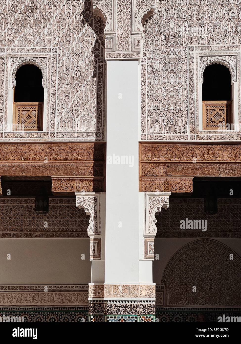 Architettura islamica intricata con pareti in stucco intagliato, motivi geometrici e balconi in legno tradizionali all'interno di un edificio storico in Marocco. - Immagine stock catturata con smartphone