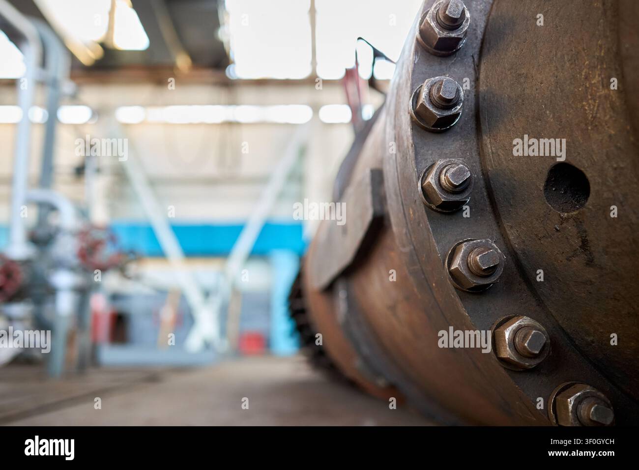 Primo piano dell'involucro di un compressore industriale che mostra un collegamento di tenuta, con connessione a vite bullonata e dadi sul pozzo di ispezione in un'industria chimica con Foto Stock