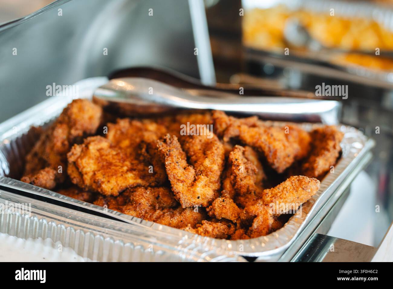 Filetti di pollo fritti croccanti in vassoio di pellicola per catering Foto Stock