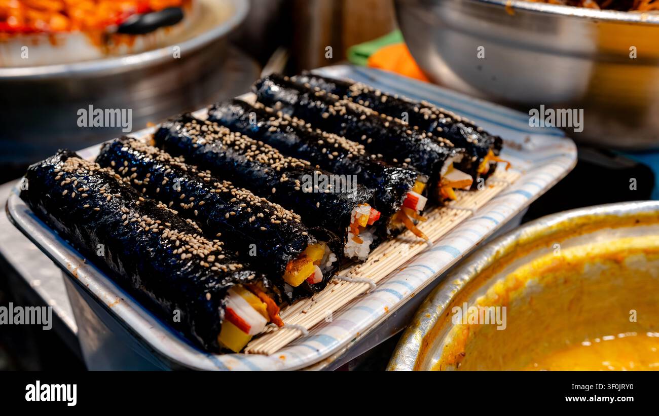 Deliziose roulette di kimbap esposte al mercato di Seong-dong a Gyeongju, in Corea del Sud. Ingredienti freschi avvolti in alghe nori, che mostrano un'autentica guarnizione coreana Foto Stock