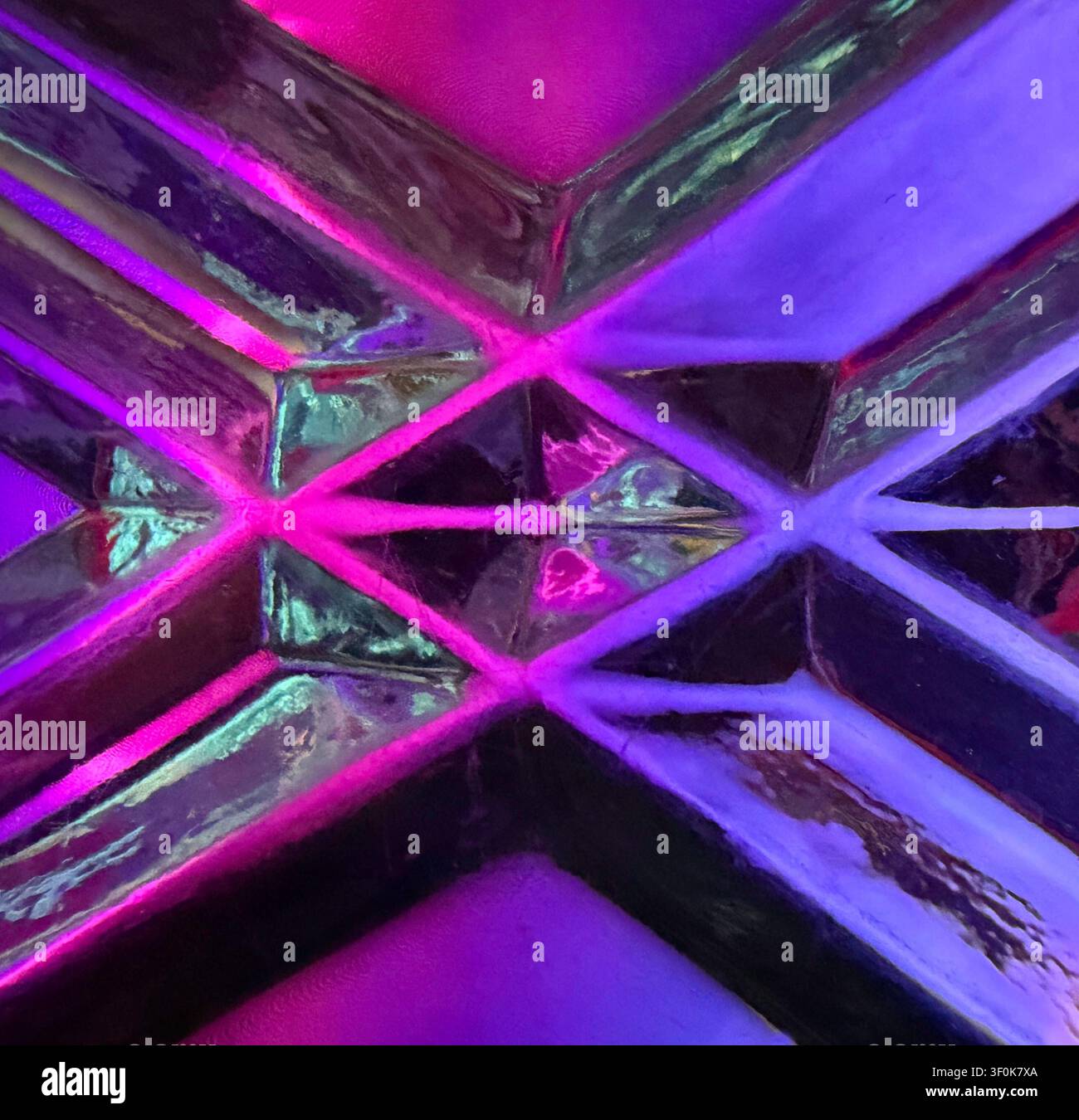 Prima piano mostra screenshot e riflessione sul vetro che creano un design astratto colorato di diamanti al neon, le linee si incontrano in una figura geometrica equilibrata e formano forma e dimensione. Foto Stock