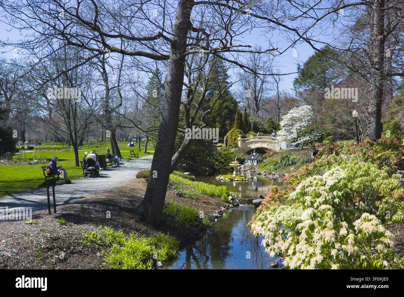 Sentiero panoramico nel parco con persone che si godono una giornata di primavera vicino a un ruscello che scorre. Giardini Pubblici, Halifax, Nuova Scozia, Canada. Foto Stock