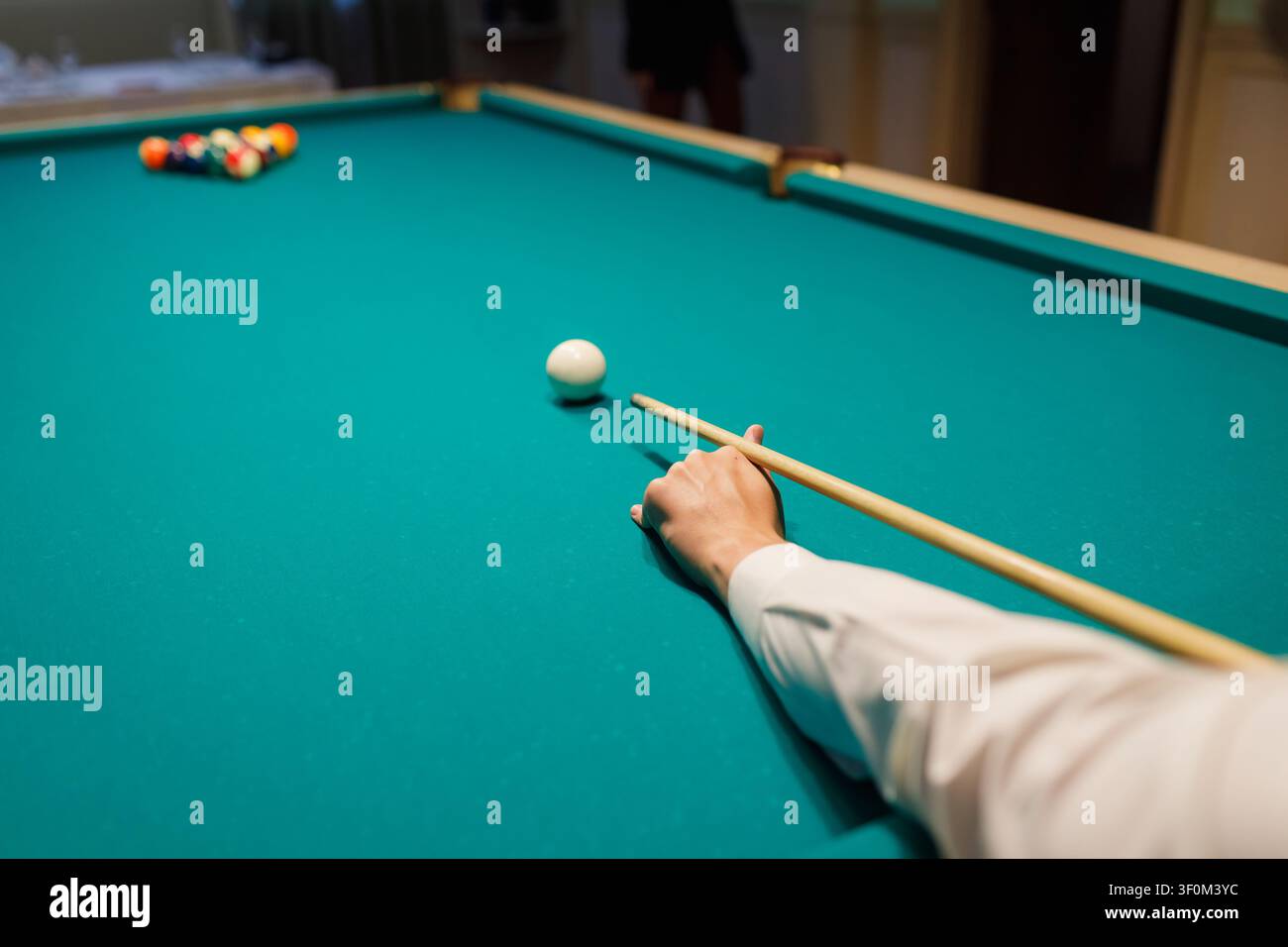 Il giocatore di biliardo gioca a snooker sul tavolo da biliardo. Foto Stock
