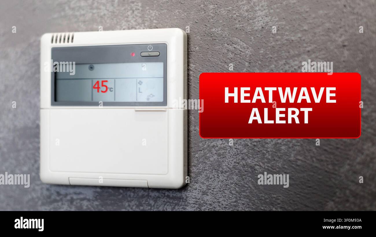 Allarme ondata di caldo visualizzato su un termostato che mostra una temperatura elevata in un ambiente domestico durante la stagione estiva Foto Stock