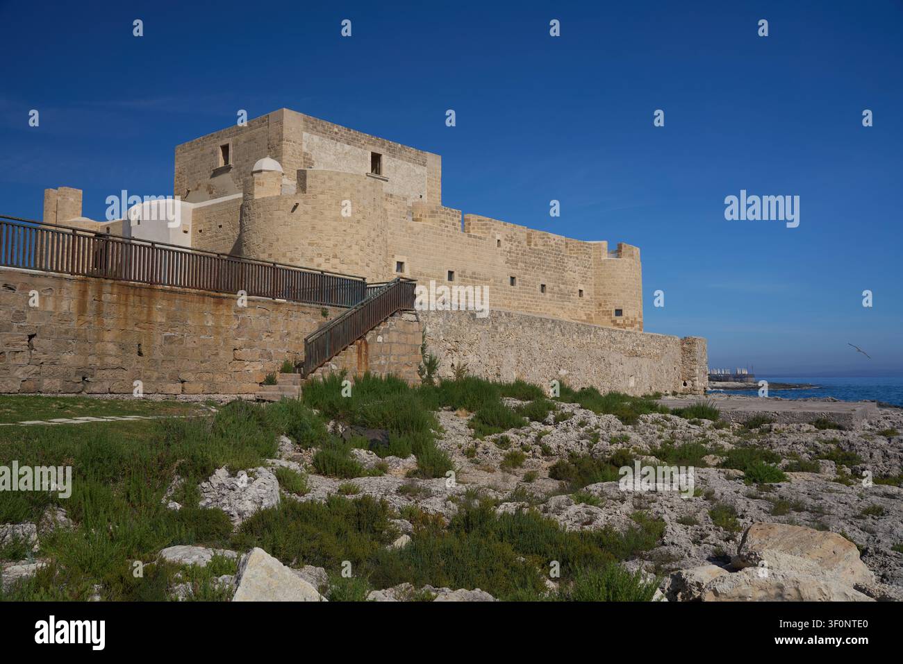 Mura della fortezza sul mare sopra una costa rocciosa a Brucoli, Sicilia Foto Stock
