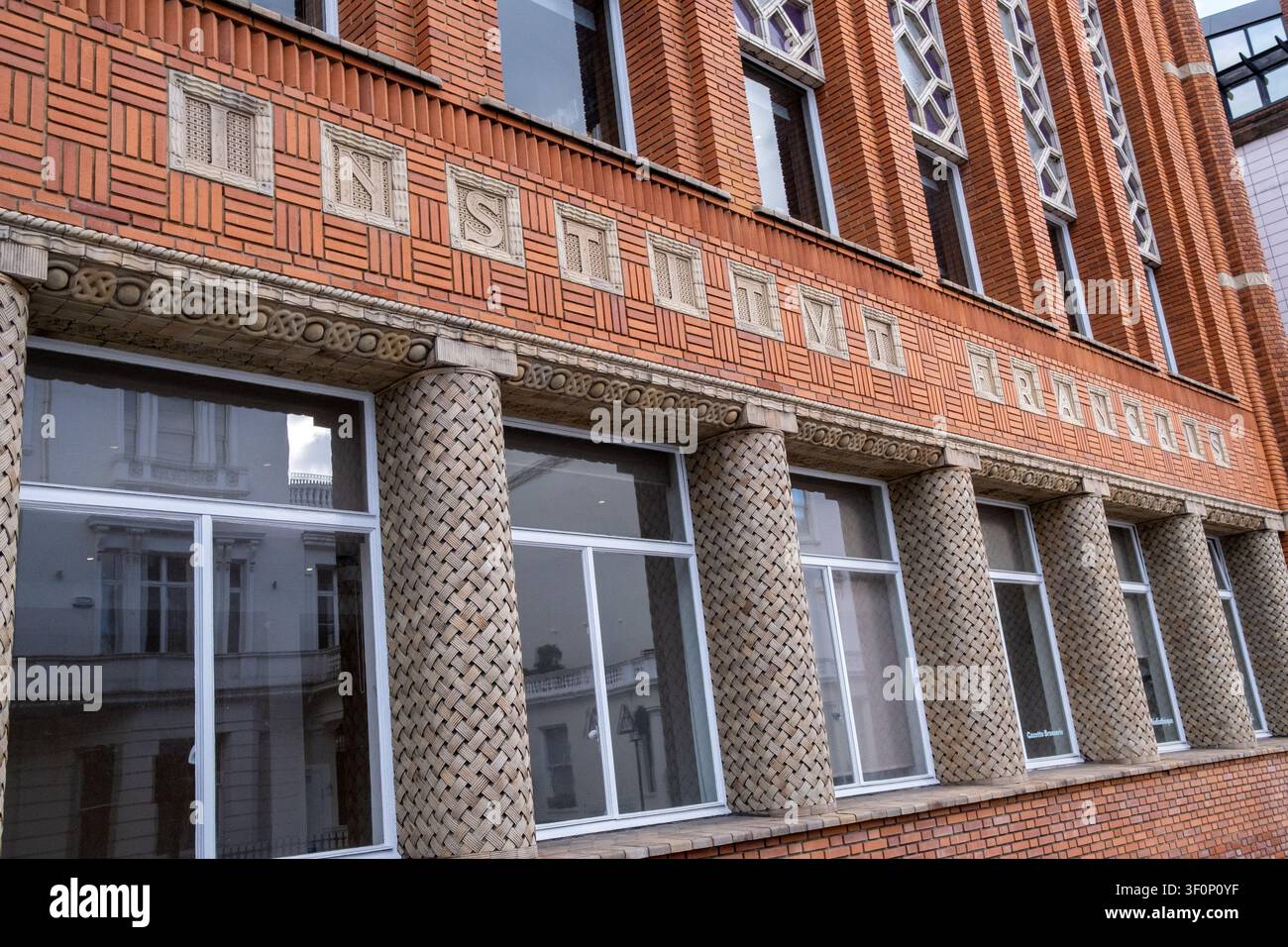 Le lettere incise "Institut Francais" si vedono sulla facciata in mattoni rossi dell'Institut francais du Royaume-Uni, con colonne decorative, riflessione della finestra Foto Stock