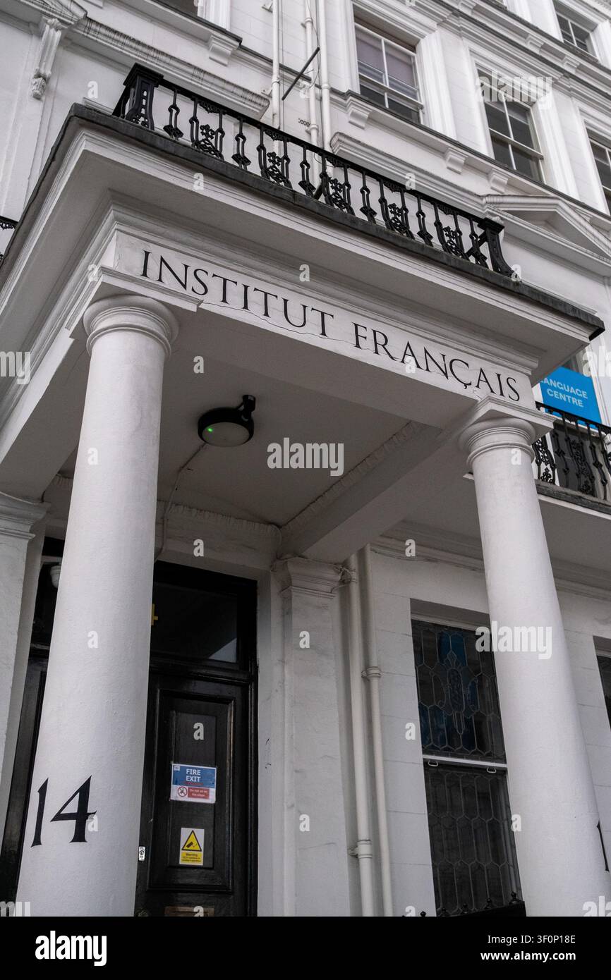 La facciata bianca dell'Institut Francais du Royaume-Uni mostra l'ingresso scolpito dell'Institut Francais, balconi in ferro nero e cartelli blu delle finestre pronti Foto Stock