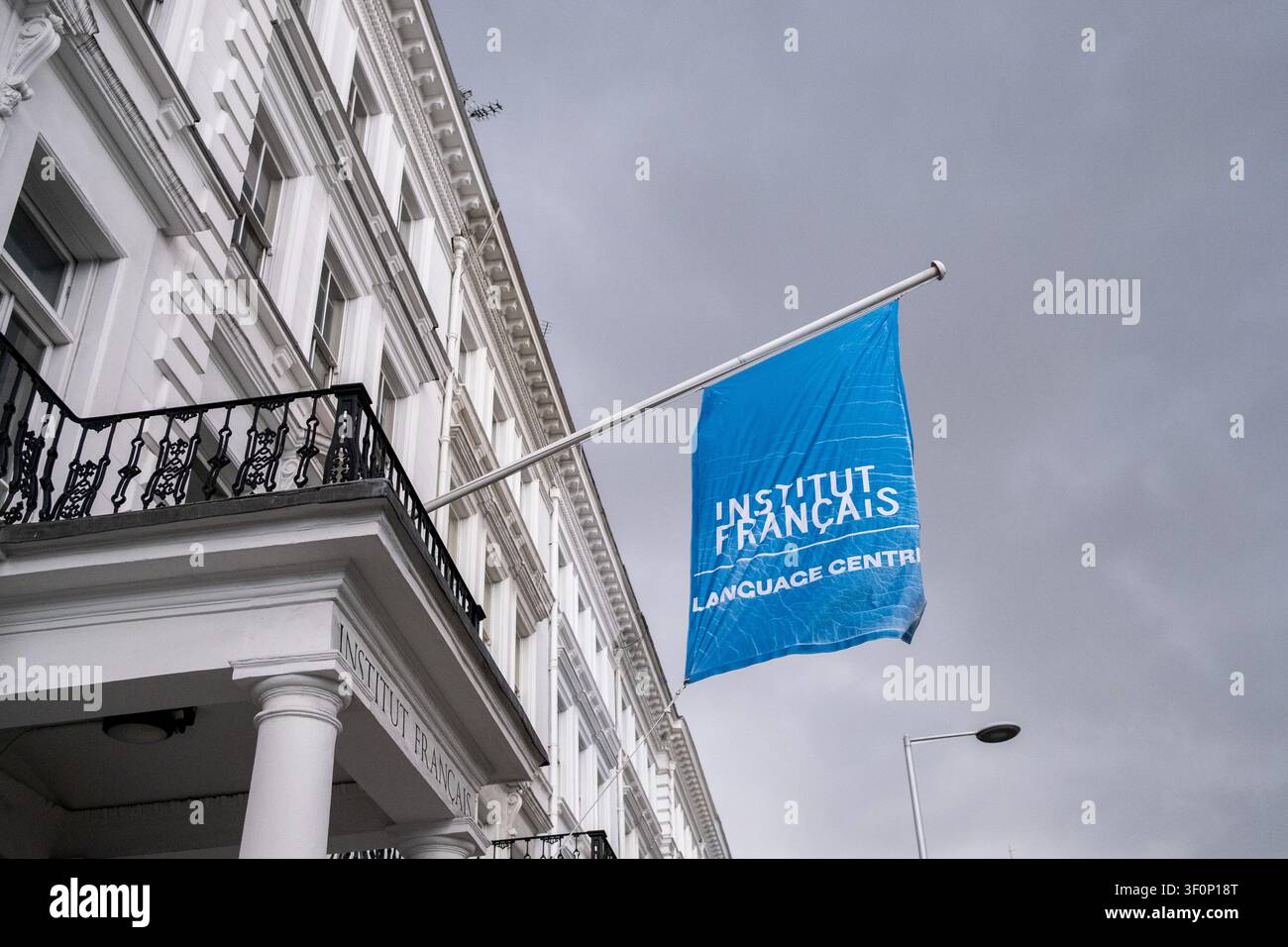 La facciata bianca dell'Institut Francais du Royaume-Uni mostra l'ingresso scolpito dell'Institut Francais, balconi in ferro nero e cartelli blu delle finestre pronti Foto Stock