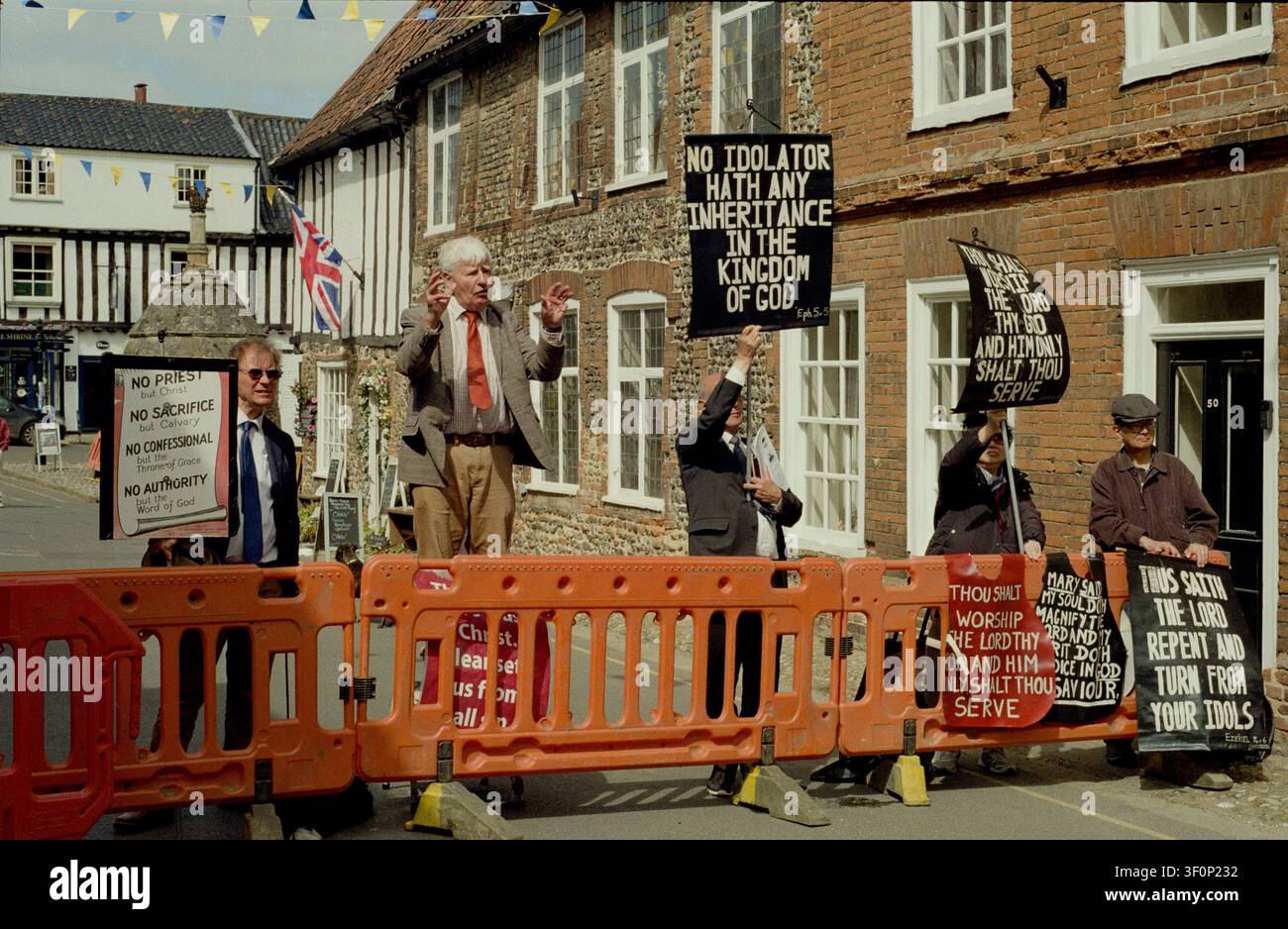 Protestanti evangelici che manifestano contro il pellegrinaggio annuale della Pentecoste a Walsingham, Norfolk. I manifestanti si oppongono al rifiuto della Chiesa anglicana di aderire ai 39 Articoli di Fede. Gli Articoli sono una serie di dichiarazioni che definiscono le dottrine e le pratiche della Chiesa d’Inghilterra, stabilita nel 1563 e finalizzata nel 1571. Riflettono la posizione teologica della Chiesa anglicana durante la Riforma inglese, bilanciando le influenze protestanti e cattoliche. Tra gli altri, proibiscono il culto di idoli, e dottrine come il purgatorio, le indulgenze e la venerazione delle reliquie. Foto Stock