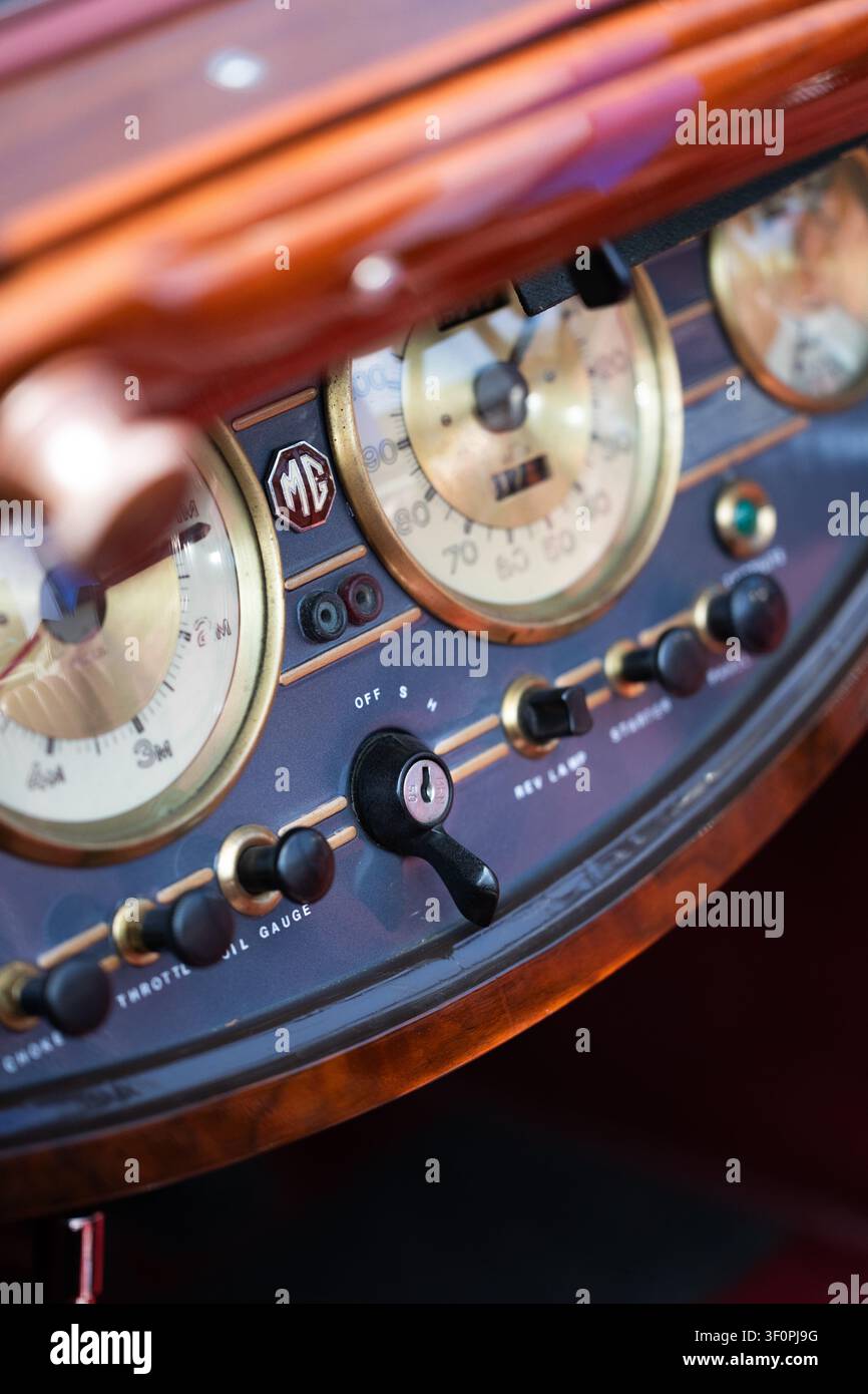 Cruscotto in legno di un'auto sportiva classica MG con tachimetro, interruttore di accensione, soffietto e comandi dell'acceleratore e badge ottagonale MG, Museo di Brooklands, W Foto Stock