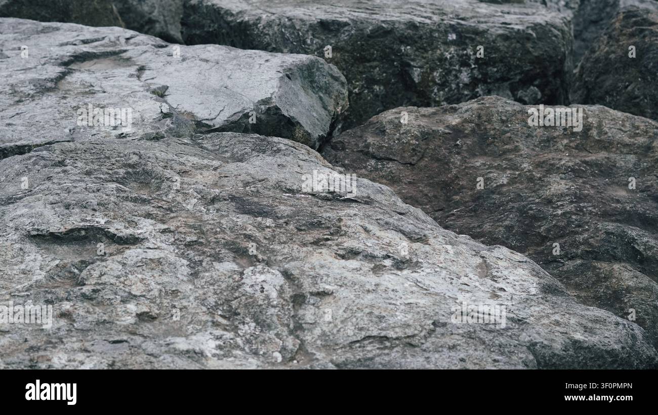 Rocce grezze naturali grigie che formano uno sfondo solido di pietra texturizzata. Foto Stock