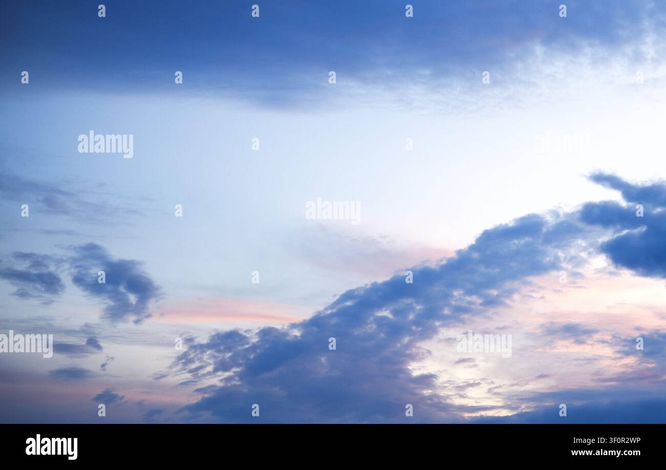 un bellissimo cielo all'alba con una sfumatura dal blu profondo al rosa tenue e all'oro Foto Stock