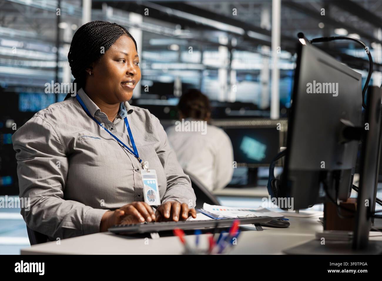 L'amministratore IT delle strutture server lavora con una workstation per aggiornare la tecnologia dei server, configurando l'attrezzatura e lavorando con il software. Foto Stock