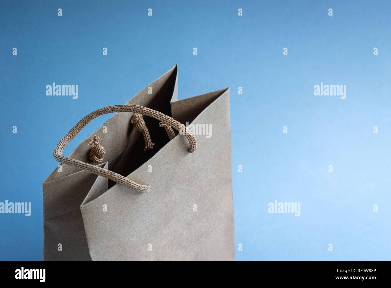 Borsa della spesa in carta marrone isolata su sfondo blu, spazio per copia. Foto Stock