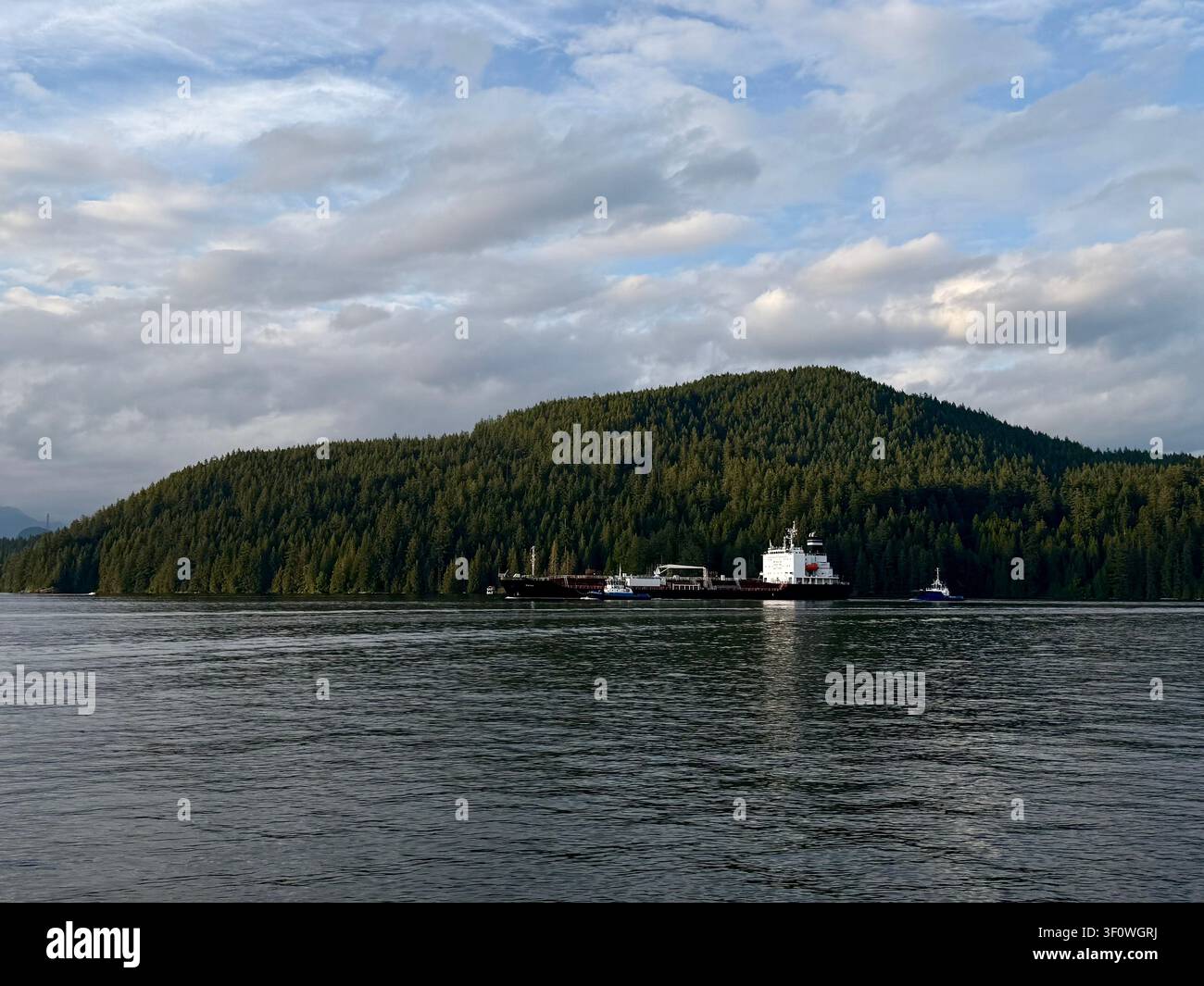 Chimera e chiglia che attraversano il Burrard Inlet al largo del Barnet Marine Park a Burnaby, Metro Vancouver, Columbia Britannica, Canada, con montagne boscose Foto Stock