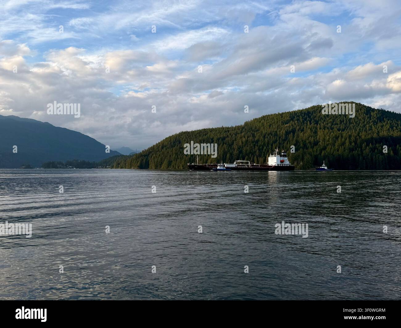 Chimera e chiglia che attraversano il Burrard Inlet al largo del Barnet Marine Park a Burnaby, Metro Vancouver, Columbia Britannica, Canada, con montagne boscose Foto Stock