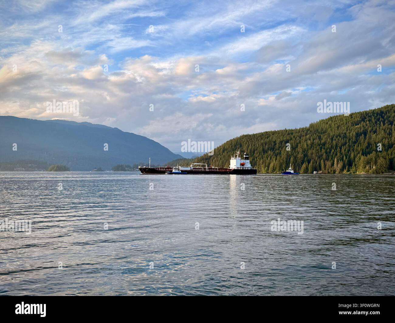 Chimera e chiglia che attraversano il Burrard Inlet al largo del Barnet Marine Park a Burnaby, Metro Vancouver, Columbia Britannica, Canada, con montagne boscose Foto Stock