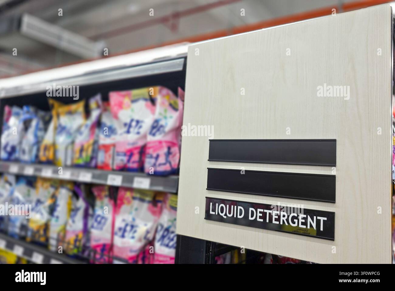 Informazioni sulla segnaletica della categoria di prodotti detergente liquido per la lavanderia domestica nel reparto di un supermercato come guida per gli acquirenti nella loro missione di acquisto. Sho Foto Stock