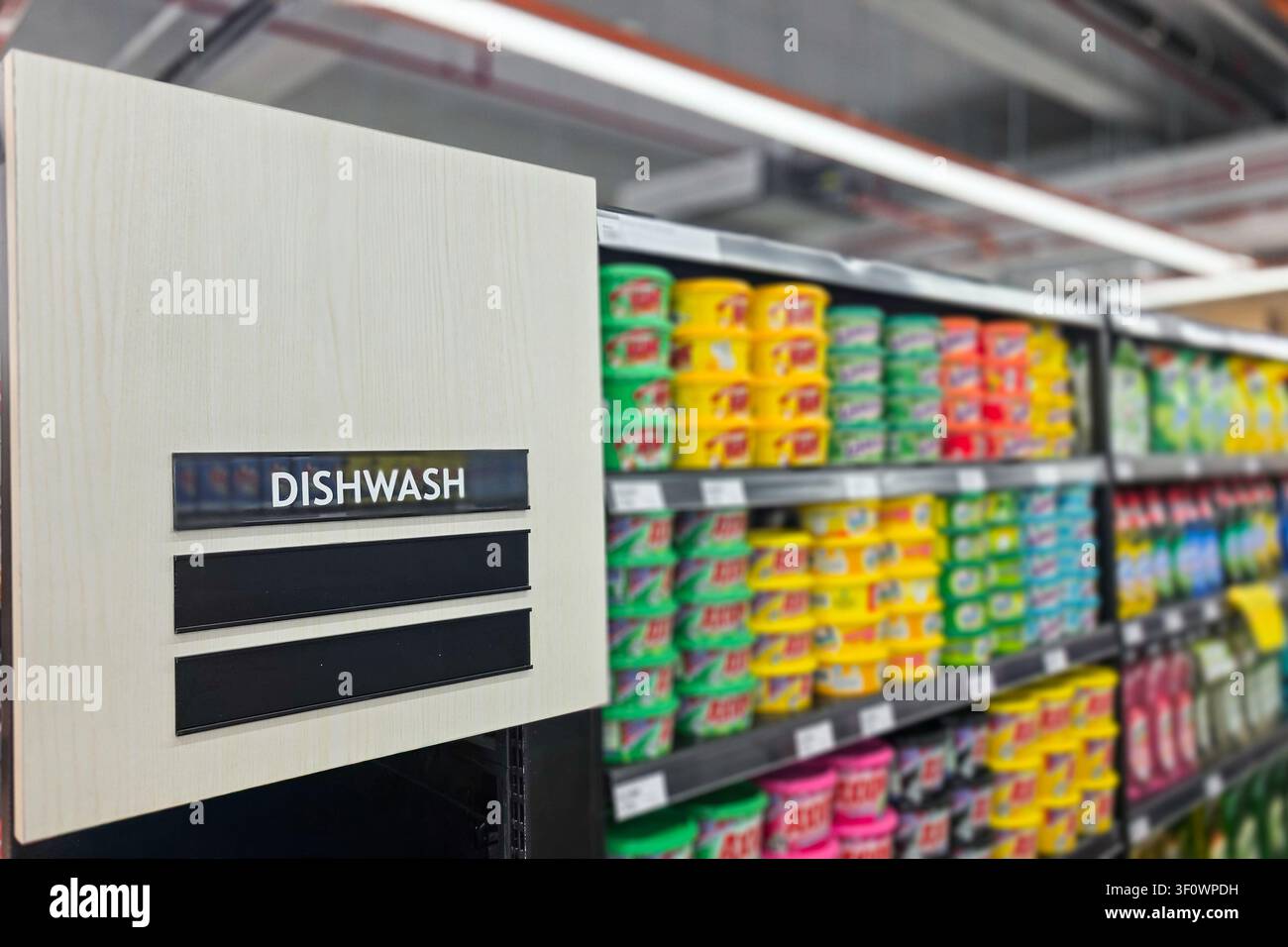Informazioni sulla categoria dei prodotti per lavastoviglie sui cartelli del reparto di un supermercato come guida per i clienti nella loro missione di acquisto. Scatto con grande profondità di campo Foto Stock