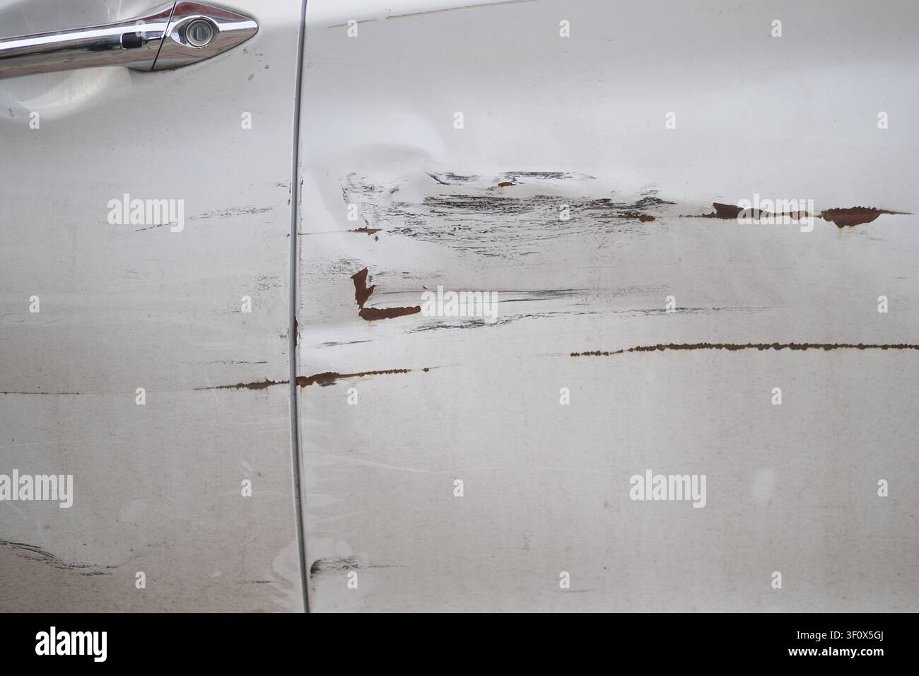 Porta dell'auto con graffi e segni di usura visibili alla luce del giorno Foto Stock