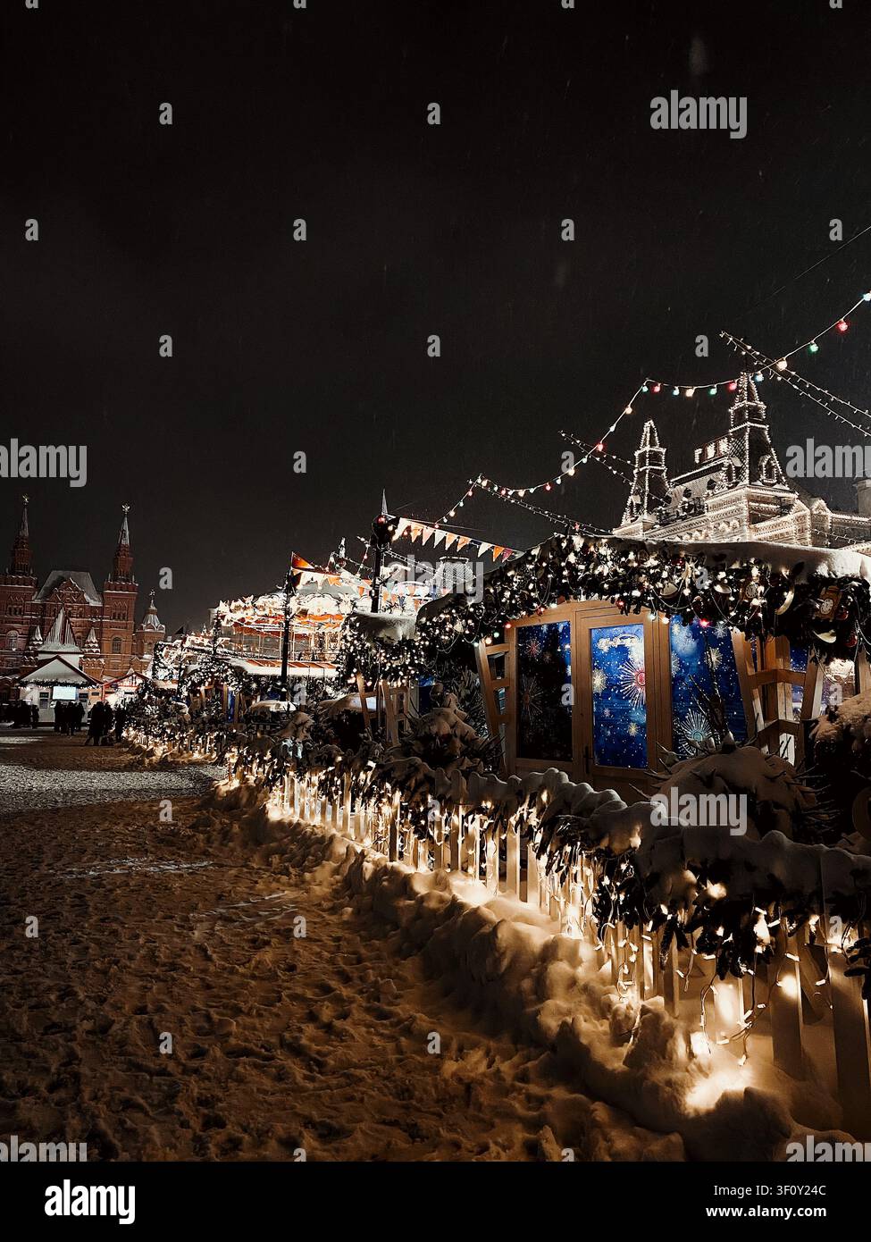 Mosca, Russia - 22 gennaio 2022: Mercato natalizio festivo con bancarelle e decorazioni illuminate durante una notte invernale innevata - Immagine stock catturata con smartphone