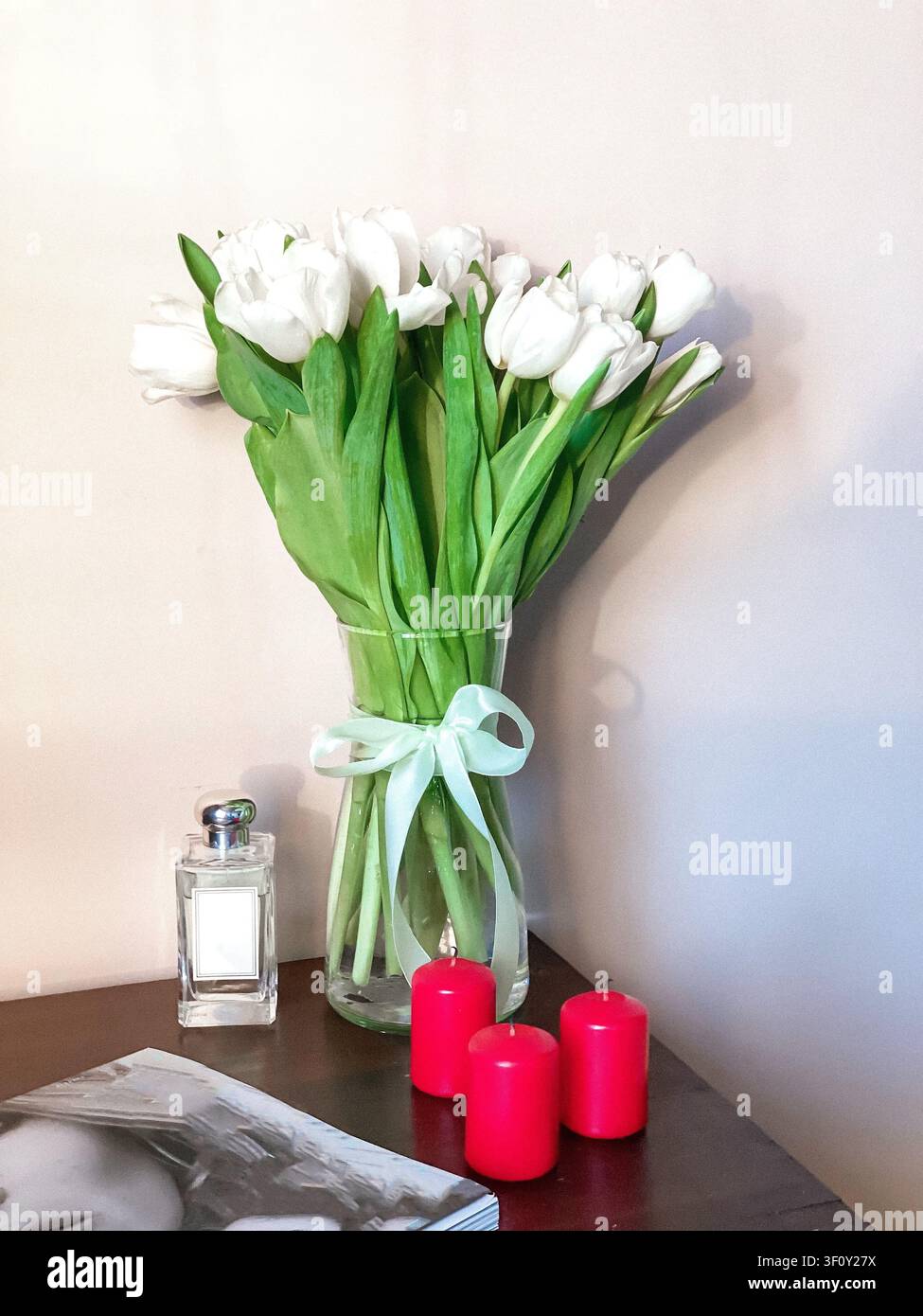 Mazzo di tulipani bianchi in vaso di vetro sul tavolo, interno accogliente della casa - Immagine stock catturata con smartphone