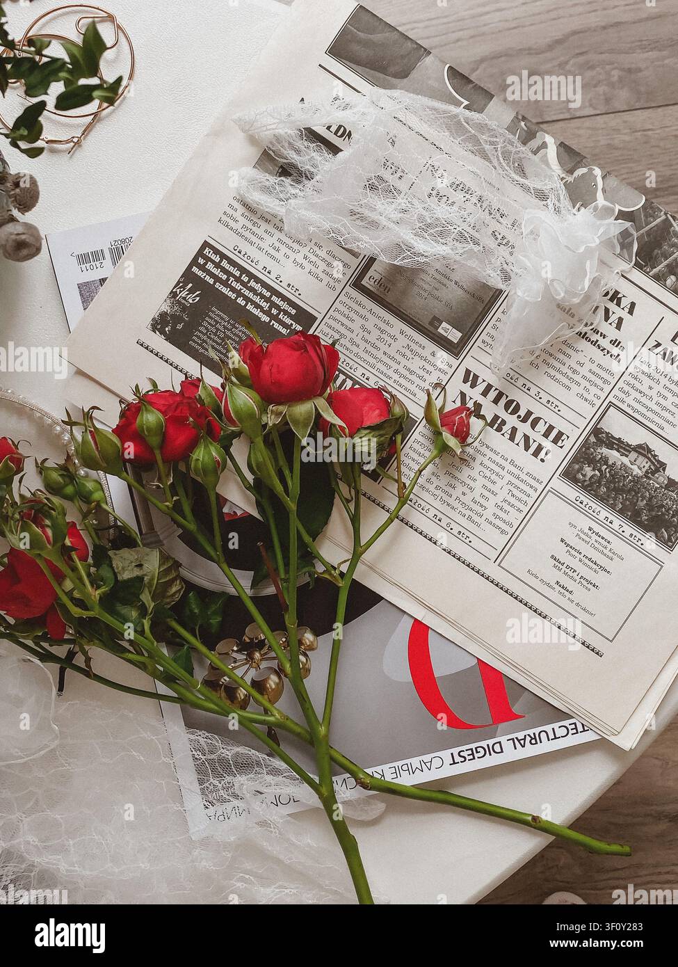 Mosca, Russia - 5 marzo 2022: Rose rosse su giornali vintage con accessori di pizzo in una composizione flat lay romantica. - Immagine stock catturata con smartphone