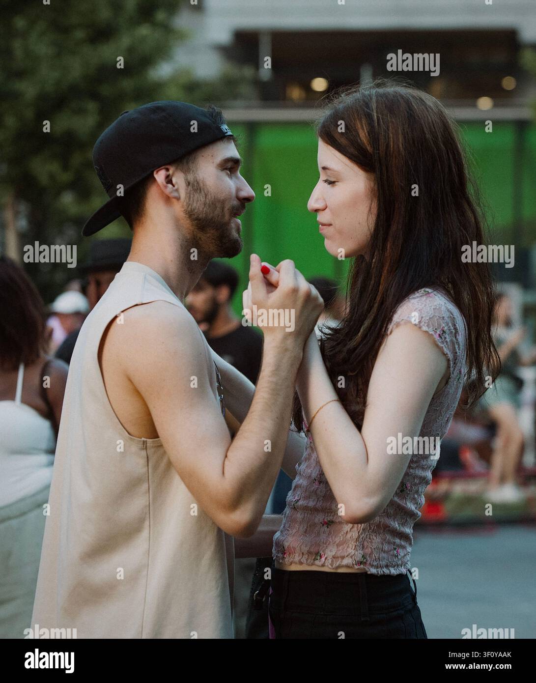 Coppia giovane che si tiene per mano e si guarda l'un l'altro Foto Stock