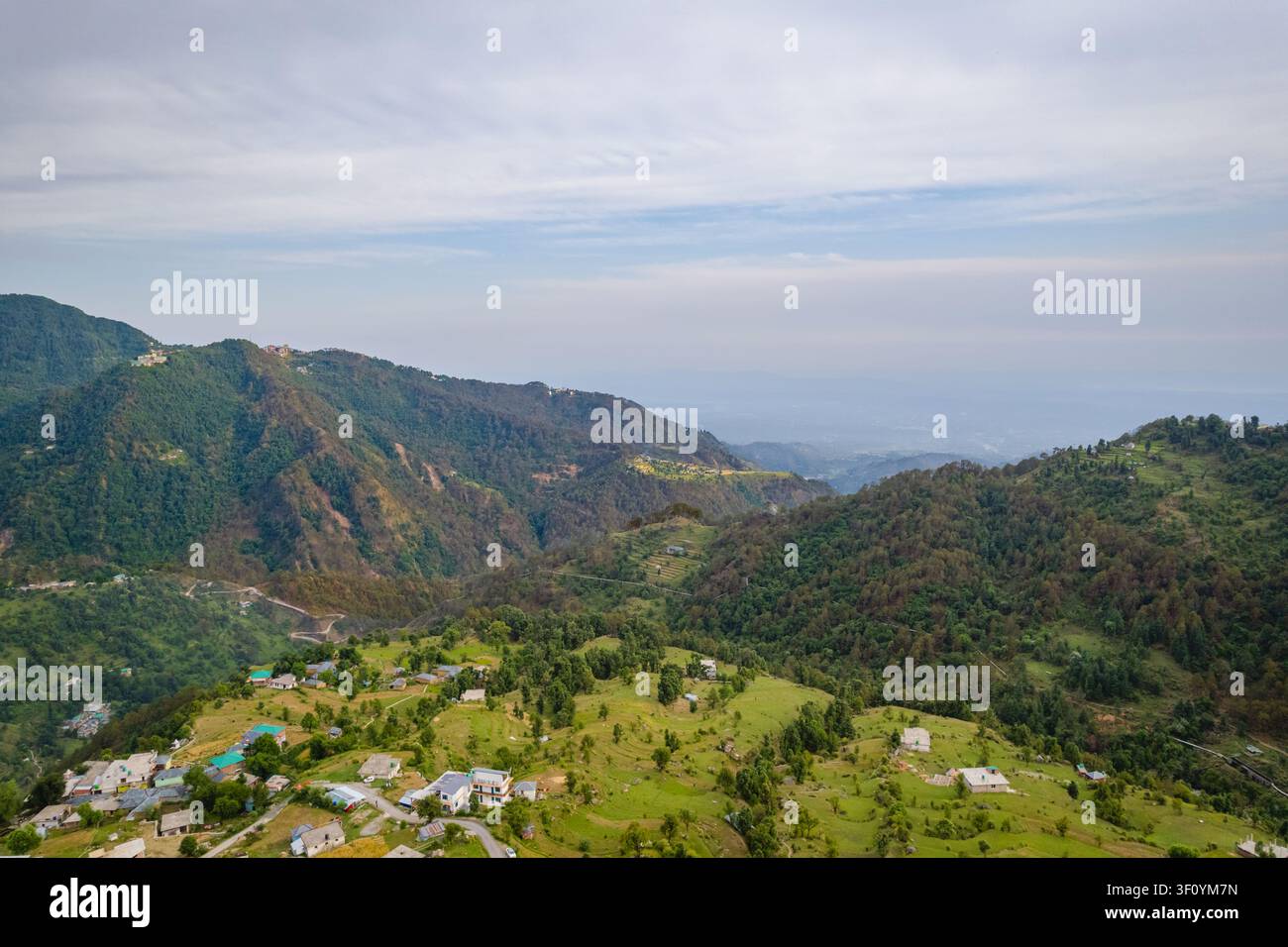 Una vista aerea cattura le vaste catene montuose verdi e il paesaggio boschivo fitto vicino al lago Kareri nell'Himachal Pradesh. Foto Stock