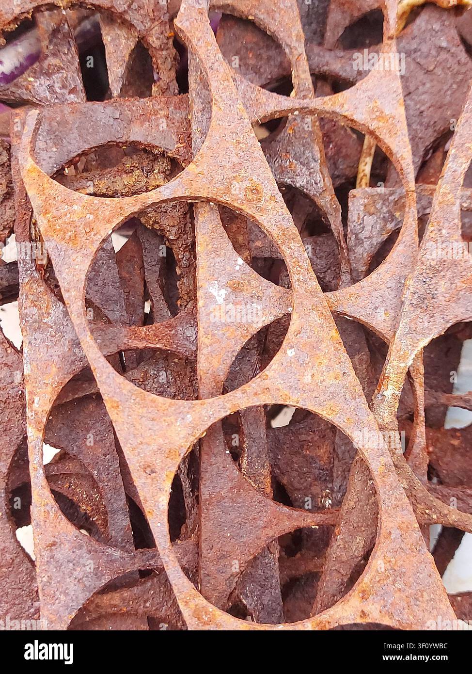Prima vista di scarti industriali di metallo arrugginiti con motivi ritagliati circolari. Texture di acciaio corrosa, forme geometriche astratte, sfondo metallico weathering, ossidazione, concetto di riciclaggio, superficie grunge, rifiuti industriali, macro dettagliata. Foto Stock