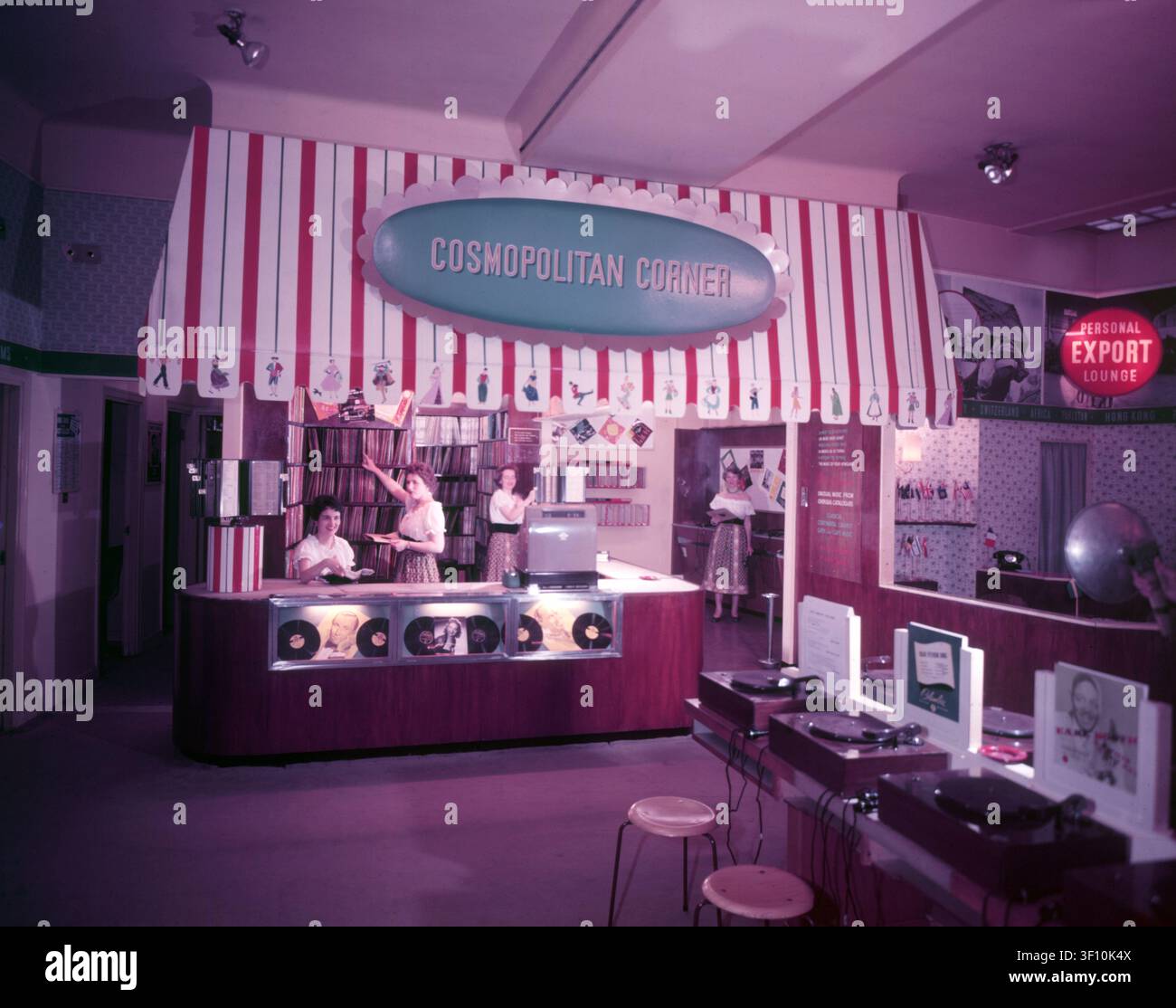 'Cosmopolitan Corner', HMV, Oxford Street, Londra, 1953. Addette alle vendite in camicette scollées. Posto di ascolto: per i clienti che desiderano ascoltare i dischi sono disponibili lettori di grammofono. Foto Stock