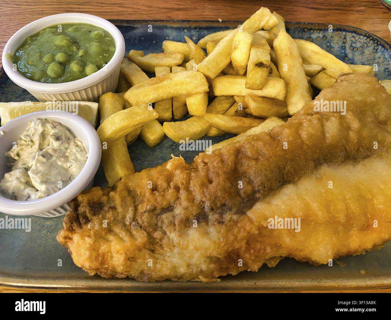 Fish and chips, pesce fritto nella pastella, patatine fritte, purè di piselli, remoulade, su un piatto, grassoso, cibo, Londra, Gran Bretagna, Gran Bretagna Foto Stock