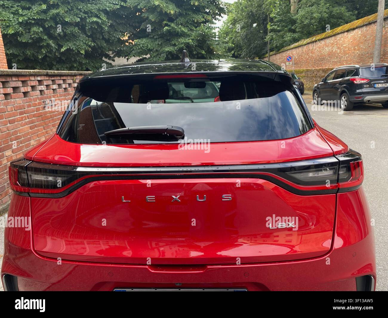 Cremona, Italia, 19 giugno 2026: Retro di un SUV compatto Lexus LBX rosso, che mostra il nome del modello, l'emblema del marchio e i fari posteriori moderni Foto Stock