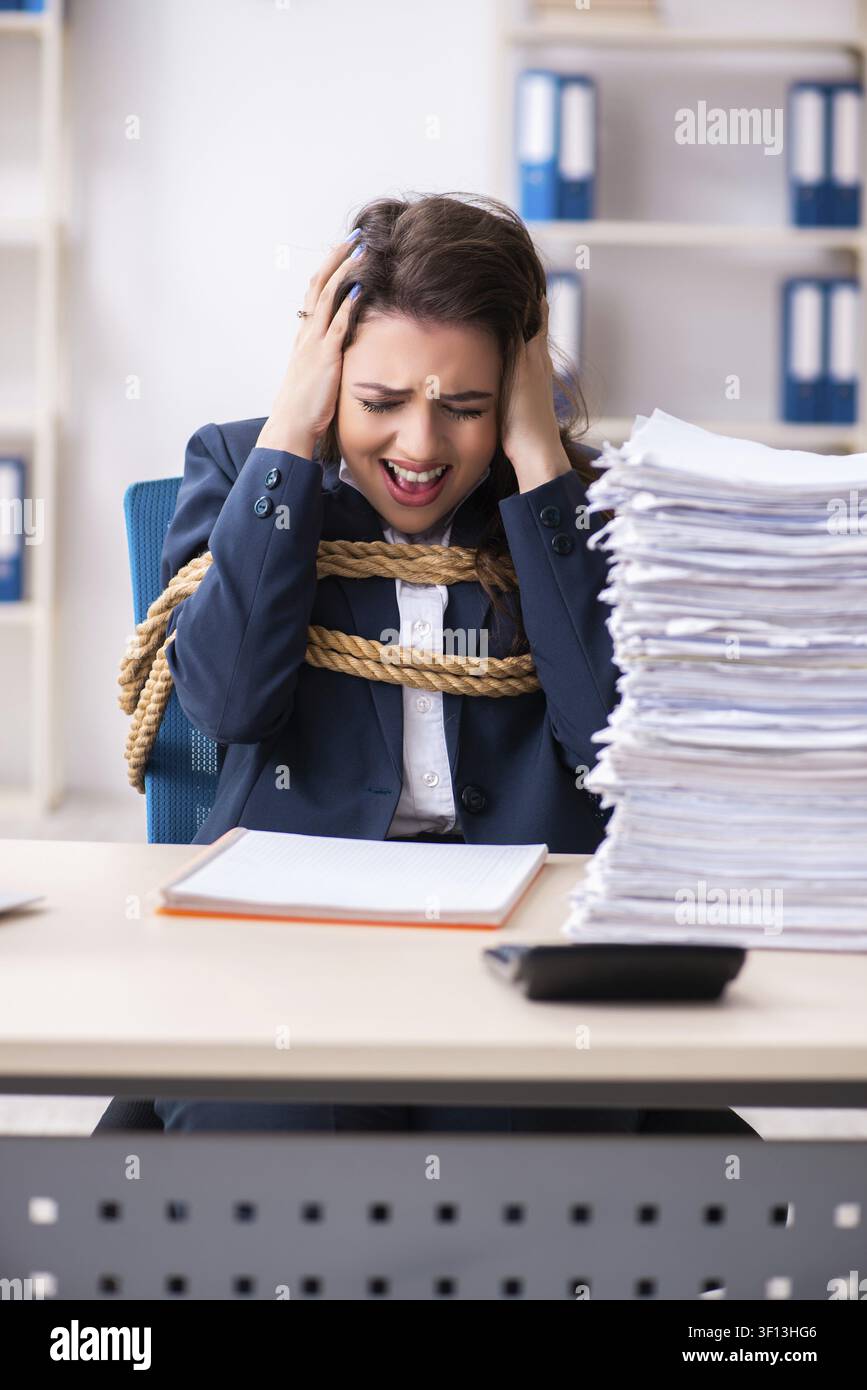 Giovane bella dipendente legato con corda in ufficio Foto Stock