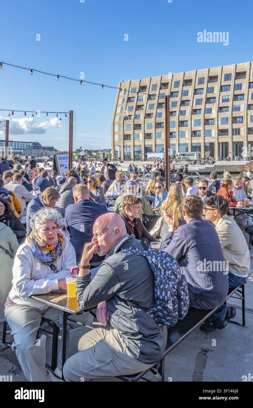 Vista sugli spazi all'aperto affollati del mercato di strada Broens Gadekokken su Strandgade verso il canale, a destra l'edificio storico in mattoni Foto Stock