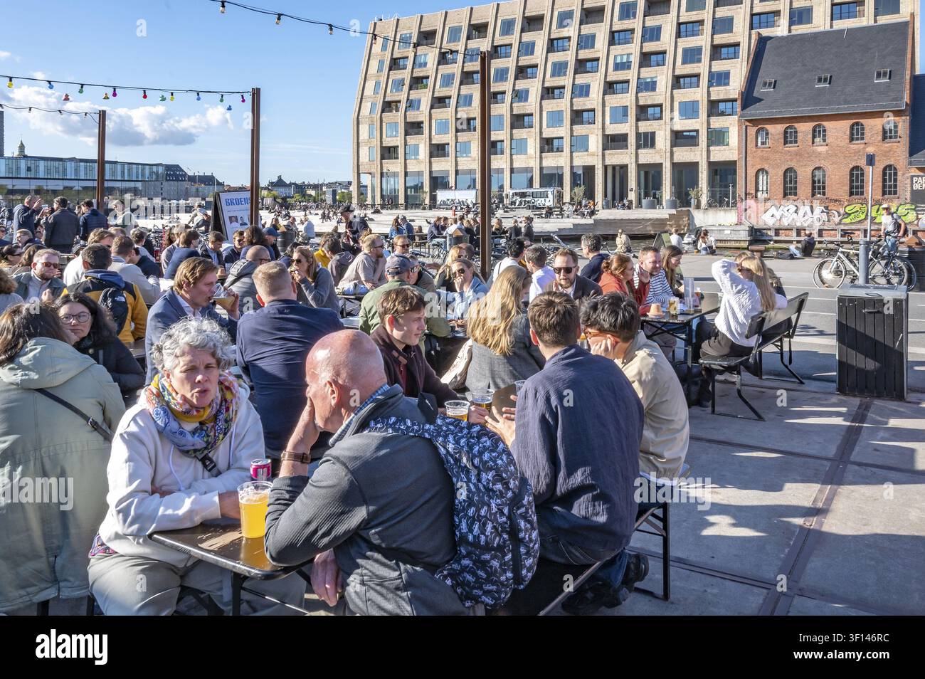 Vista sugli spazi all'aperto affollati del mercato di strada Broens Gadekokken su Strandgade verso il canale, a destra l'edificio storico in mattoni Foto Stock