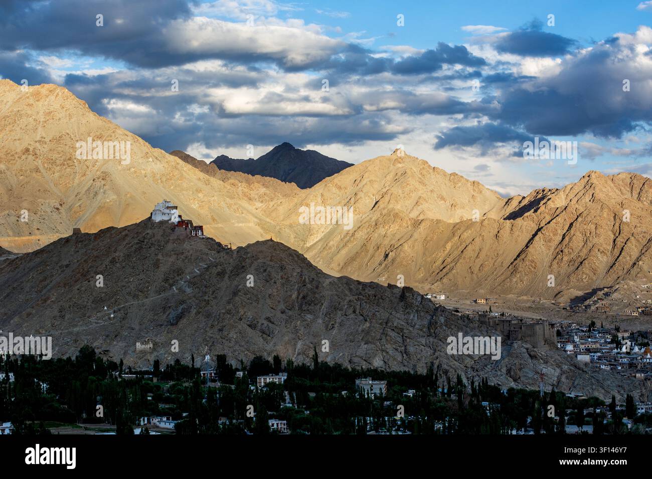 Una vista panoramica rivela il monastero di Namgyal Tsemo arroccato su una collina arida, con la città di Leh che si estende nella valle tra fitti alberi verdi Foto Stock