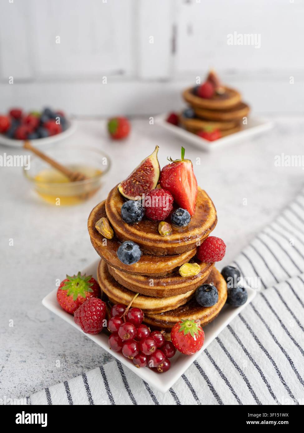 Alta pila di waffle fatti in casa serviti con frutti di bosco freschi, fichi e frutta di stagione Foto Stock