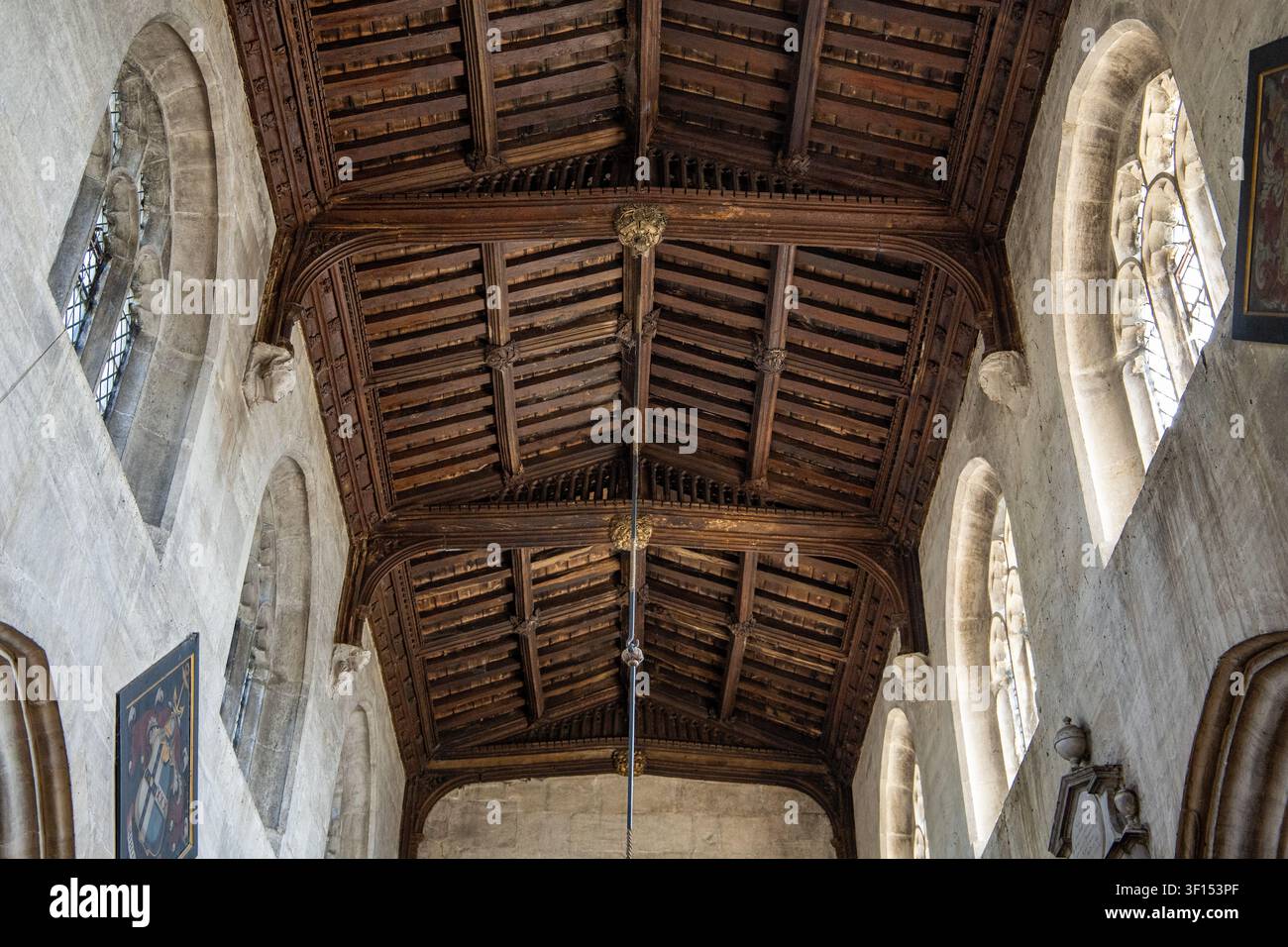 Vista ad angolazione bassa verso l'alto verso l'intricato soffitto a cassettoni in legno scuro di un interno di chiesa in pietra storica con finestre ad arco, Holy Cross Church Seend Foto Stock