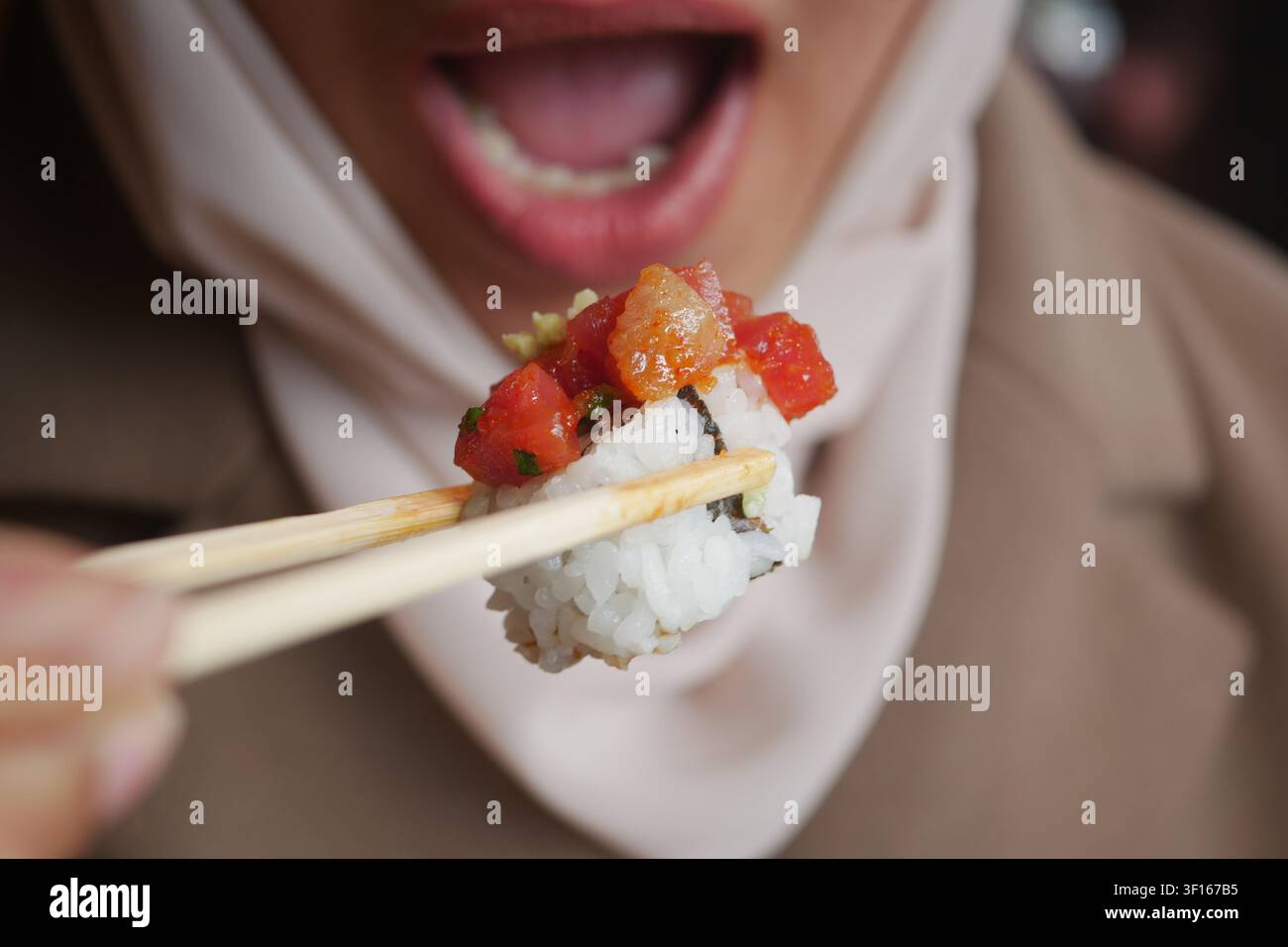 Godendo un delizioso momento di sushi con le bacchette Foto Stock
