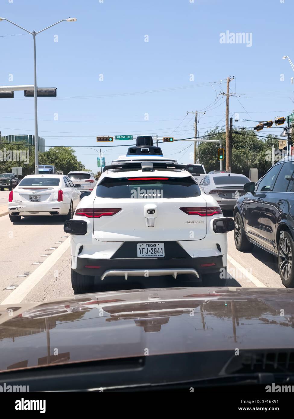 DALLAS, TX, USA - 10 LUGLIO 2026: Un Jaguar I-PACE marchiato Waymo è visto fermo a un semaforo, dotato di tecnologia di guida autonoma. Waymo Foto Stock